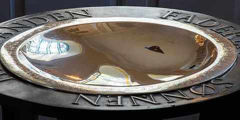 Nærbillede af marmorenglehoved med vinger på kirkeinventar.