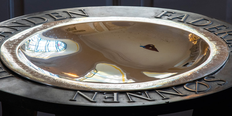 Nærbillede af marmorenglehoved med vinger på kirkeinventar.