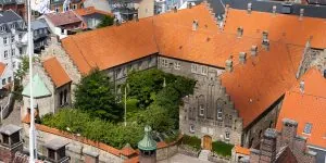 Luftfoto af historisk klostergård med røde tegltage.