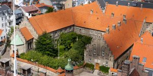 Luftfoto af historisk klostergård med røde tegltage.