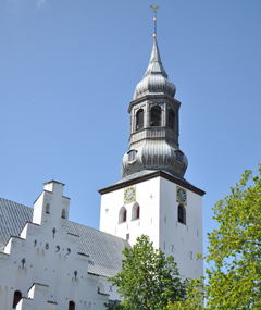 Nærbillede af historisk kirketårn med buet kobberkuppel.