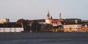 Historisk bybillede med fremtrædende hvidt kirketårn.