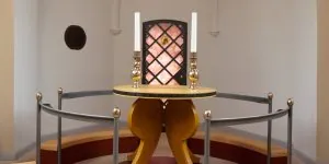 Moderne kirkealter med geometrisk lyskasse og høje lys.